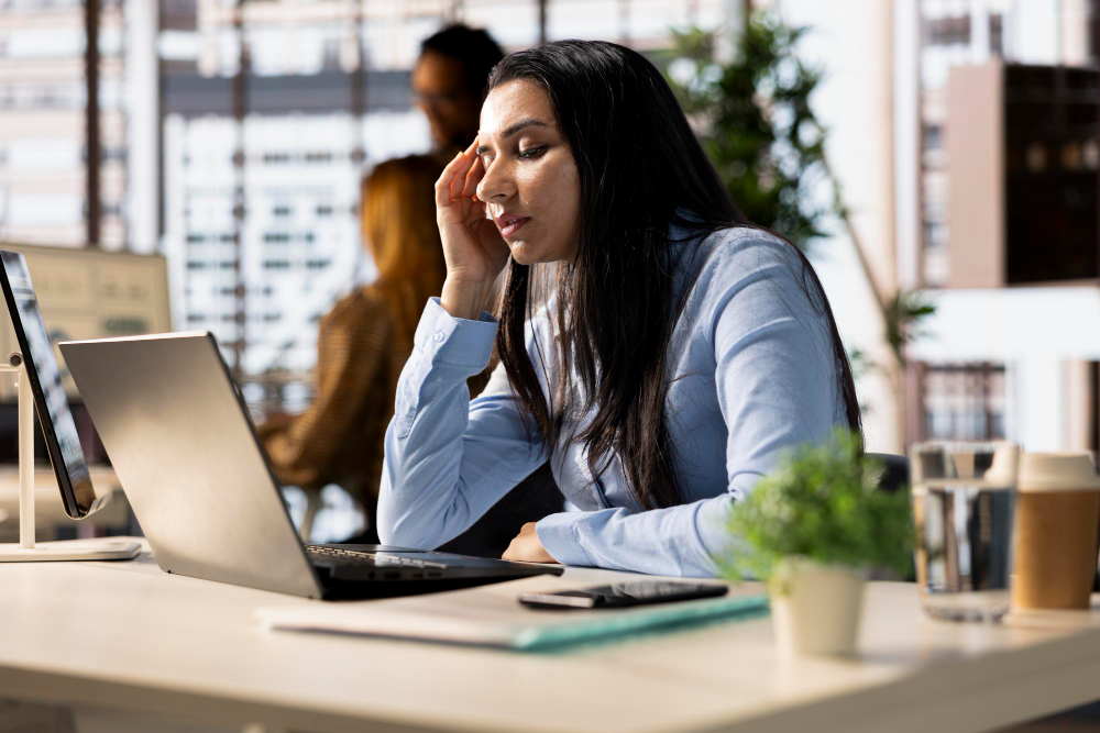 une femme fatiguée à son bureau