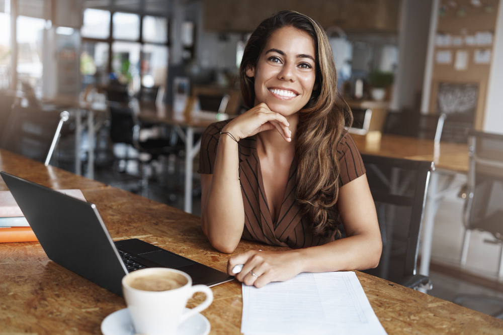 une femme souriante devant son ordinateur